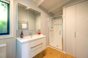 un baño con lavabo y ducha en Black Cottage - Stay Waiheke, en Waiheke Island 14 fotos más