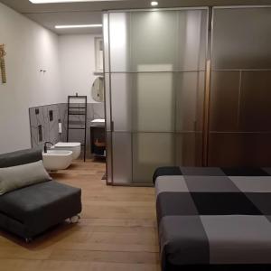 a bathroom with a bed and a couch and a toilet at CasettaLuce in Cuneo +23 photos