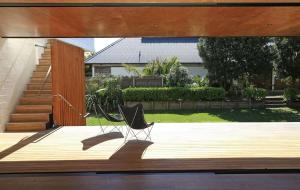 a chair sitting on top of a wooden deck at Number Five - Stay Waiheke in Onetangi