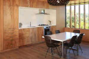 a kitchen with a table and chairs in a room at Number Five - Stay Waiheke in Onetangi