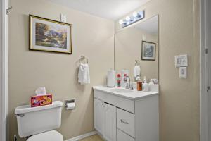 ein Badezimmer mit Toilette, Waschbecken und Spiegel in der Unterkunft 3BR Home • Near Maverik Center & Valley Fair in West Valley City