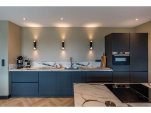 Modern villa in De Cocksdorp near the beach في دي كوكْسدوربْ: مطبخ مع حوض وموقد