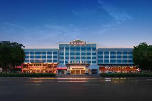 a large building with a sign on top of it at Vienna Hotel Hubei Jinzhou Changjiang University in Caoshi