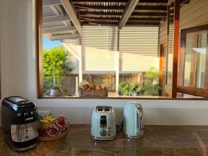 Una cocina con dos tostadoras en una encimera junto a una ventana. en East Brisbane Federation-Style Pool Villa, en Brisbane