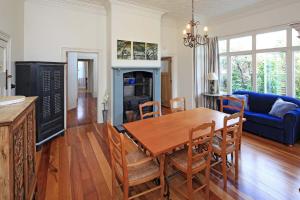 Crescent Villa - Stay Waiheke في Ostend: مطبخ وغرفة طعام مع طاولة وكراسي