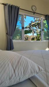 ein Schlafzimmer mit einem Bett und einem großen Fenster in der Unterkunft Mountain view Villa Private Tropical Garden in Chiang Dao