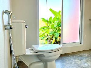 ein Bad mit einem WC, einem Fenster und einer Pflanze in der Unterkunft Mountain view Villa Private Tropical Garden in Chiang Dao + 26 Fotos