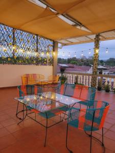 a table and chairs on a patio with lights at El hostal de Uriel in Izalco