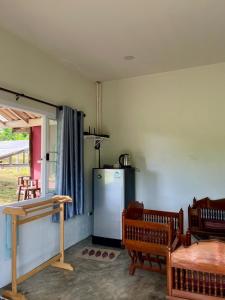 eine Küche mit einem Kühlschrank sowie einem Tisch und Stühlen in der Unterkunft Mountain view Villa Private Tropical Garden in Chiang Dao