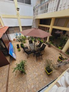 a patio with a table and chairs and an umbrella at El hostal de Uriel in Izalco +3 photos