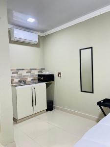a white kitchen with a sink and a mirror at PholaBnB in Pongola +7 photos