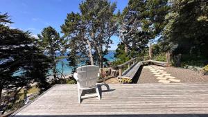 a white chair sitting on top of a wooden deck at Viewpoint - Stay Waiheke in Onetangi