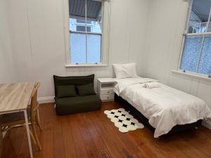 Un dormitorio con una cama, una silla y un escritorio. en East Brisbane Federation-Style Pool Villa, en Brisbane 41 fotos más