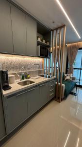 Una cocina con fregadero y un sofá en una habitación. en Charming apartment with balcony a few minutes apto from Barra, en Salvador