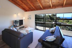 a living room with two couches and a large window at Church Bay Views - Stay Waiheke in Oneroa +23 photos