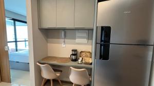 una pequeña cocina con nevera y 2 sillas en Charming apartment with balcony a few minutes apto from Barra, en Salvador