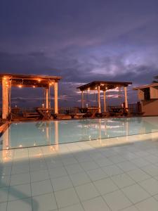 una piscina con mesas y sillas por la noche en Rock Fort Beach Resort, en Unawatuna