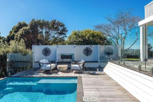 a backyard with a swimming pool and a house at No 63 - Stay Waiheke in Onetangi