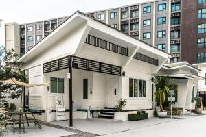a white house with a building in the background at anhaus chiangrai in Chiang Rai