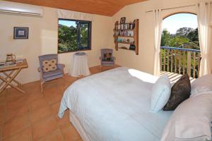 a bedroom with a large bed and a balcony at La Maisonette - Stay Waiheke in Onetangi