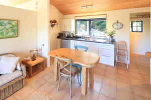 a kitchen with a wooden table in a room at La Maisonette - Stay Waiheke in Onetangi