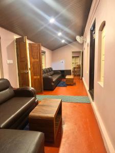 a living room with couches and a coffee table at Bucolic Resort in Panamaram