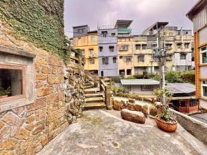 a stone wall with stairs and buildings in the background at 隱山居 海景包棟2-10人 in Jiufen