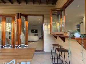Un comedor con mesa y sillas y un dormitorio. en East Brisbane Federation-Style Pool Villa, en Brisbane