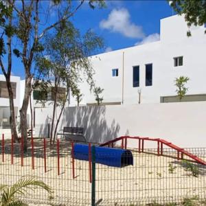 a playground in front of a white building at Vacation Home in Playa Del Carmen in Playa del Carmen