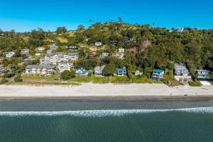 an aerial view of a beach with houses on a hill at Wavesong - Stay Waiheke in Onetangi