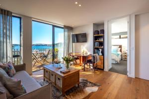 a living room with a couch and a table at Wavesong - Stay Waiheke in Onetangi +16 photos