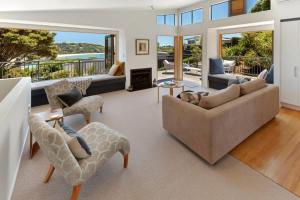 a living room with a couch and chairs at The Cove at Little O - Stay Waiheke in Oneroa