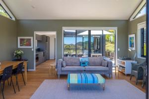 uma sala de estar com um sofá e uma mesa em Art Lovers Retreat - Stay Waiheke em Onetangi