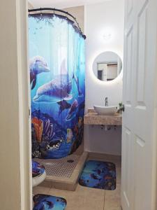 a bathroom with an aquarium themed shower curtain at Vacation Home in Playa Del Carmen in Playa del Carmen