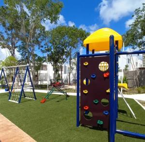 a playground with a rock wall and a slide at Vacation Home in Playa Del Carmen in Playa del Carmen
