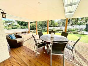 a dining room with a table and chairs on a deck at Getaway Waiheke- Stay Waiheke in Oneroa