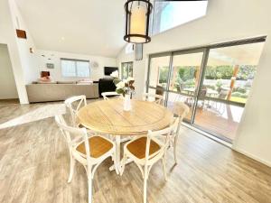 a dining room table and chairs in a living room at Getaway Waiheke- Stay Waiheke in Oneroa +19 photos