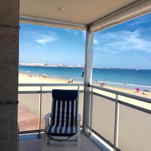 Pineda Beach PORT AVENTURA في لا بينيدا: كرسي جالس على شرفة تطل على الشاطئ