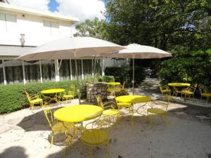 un gruppo di tavoli e sedie gialli con ombrelloni di Hotel de l'île ad Avignone