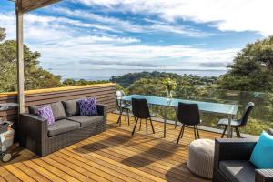 欧尼罗亚Hekerua Heights - Stay Waiheke的甲板上配有沙发和桌椅