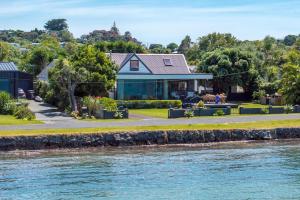a house on the shore of a river at Alhambra - Stay Waiheke in Oneroa