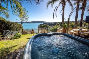 Te Whau BayPalms on Kennedy Point - Stay Waiheke的享有水景的庭院内的热水浴池