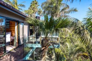 Te Whau BayPalms on Kennedy Point - Stay Waiheke的房屋阳台上的棕榈树