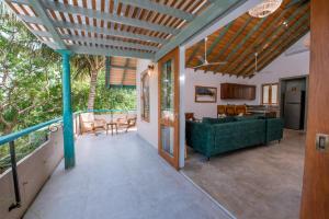a living room with a green couch on a balcony at Sithagi River Front Villa Weligama in Weligama