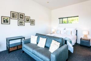 a living room with a bed and a couch at Delamore Cove - Kauri - Stay Waiheke in Matiatia Bay