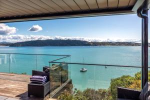 Un balcón con vista a un cuerpo de agua. en Moana Retreat - Stay Waiheke, en Putaki Bay