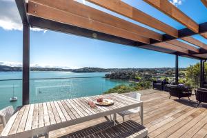 Una terraza con mesa y sillas y vista al agua. en Moana Retreat - Stay Waiheke, en Putaki Bay 41 fotos más