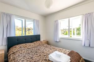 En eller flere senge i et værelse på Roses Bach - Stay Waiheke + 14 billeder