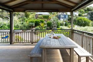 una mesa de picnic de madera en una terraza de madera en Miro Magic - Stay Waiheke, en Palm Beach