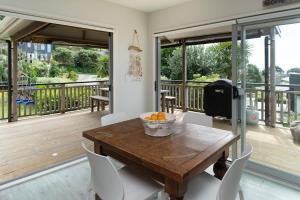 comedor con mesa de madera y balcón en Miro Magic - Stay Waiheke, en Palm Beach 8 fotos más